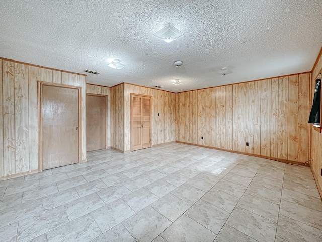 unfurnished bedroom featuring two closets and wood walls