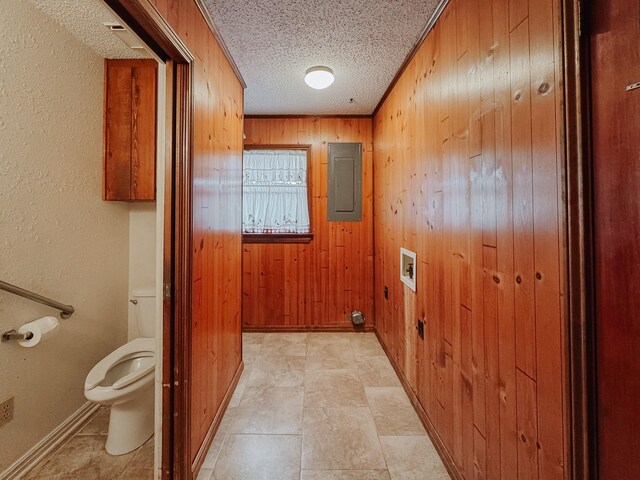 unfurnished room featuring wooden walls and a textured ceiling