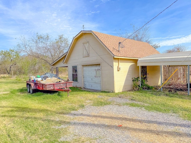 view of home's exterior with a yard, a garage, a carport, and an outdoor structure