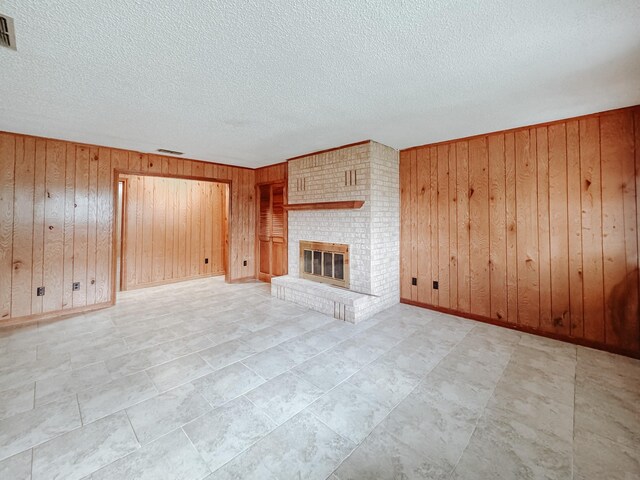 details with wood walls, a fireplace, and a textured ceiling