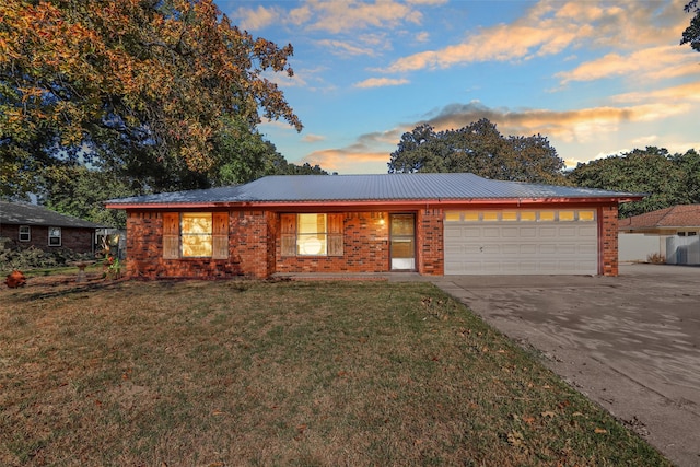 ranch-style home featuring a lawn and a garage