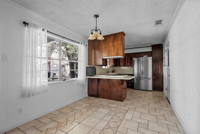 kitchen featuring stainless steel fridge, kitchen peninsula, a textured ceiling, and an inviting chandelier