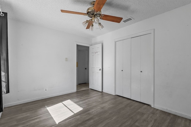 unfurnished bedroom featuring a textured ceiling and dark hardwood / wood-style floors