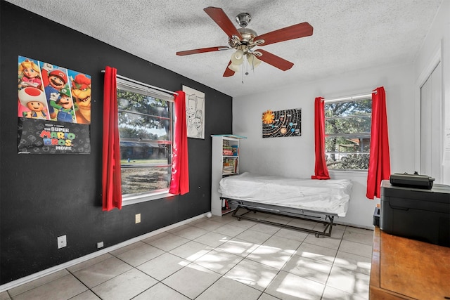 unfurnished bedroom featuring a textured ceiling, ceiling fan, and light tile patterned flooring