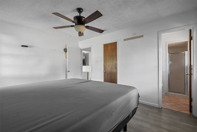 bedroom with a textured ceiling, dark hardwood / wood-style flooring, ensuite bathroom, and ceiling fan