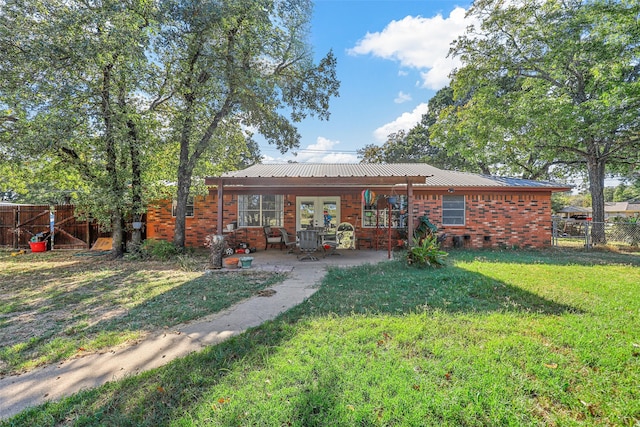 rear view of house featuring a patio area and a lawn