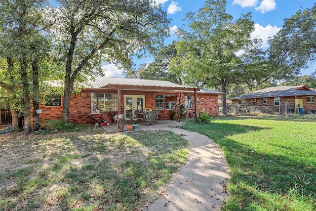 back of house with a lawn, a patio area, and french doors