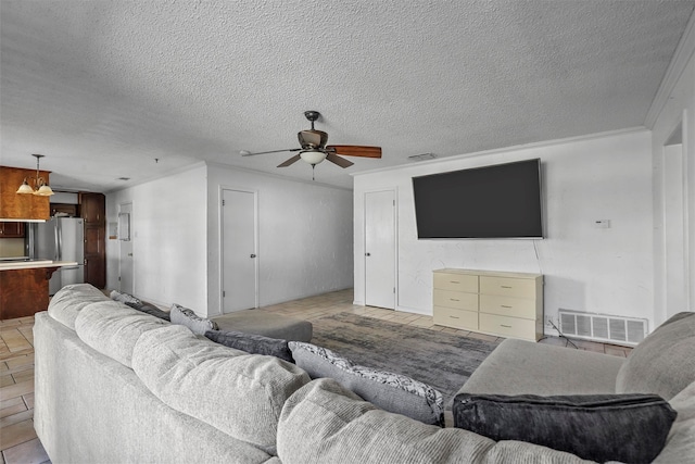 living room featuring ceiling fan with notable chandelier, a textured ceiling, and ornamental molding