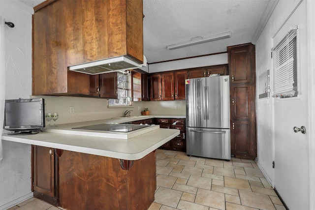 kitchen featuring stainless steel fridge, black electric cooktop, a textured ceiling, kitchen peninsula, and a breakfast bar area