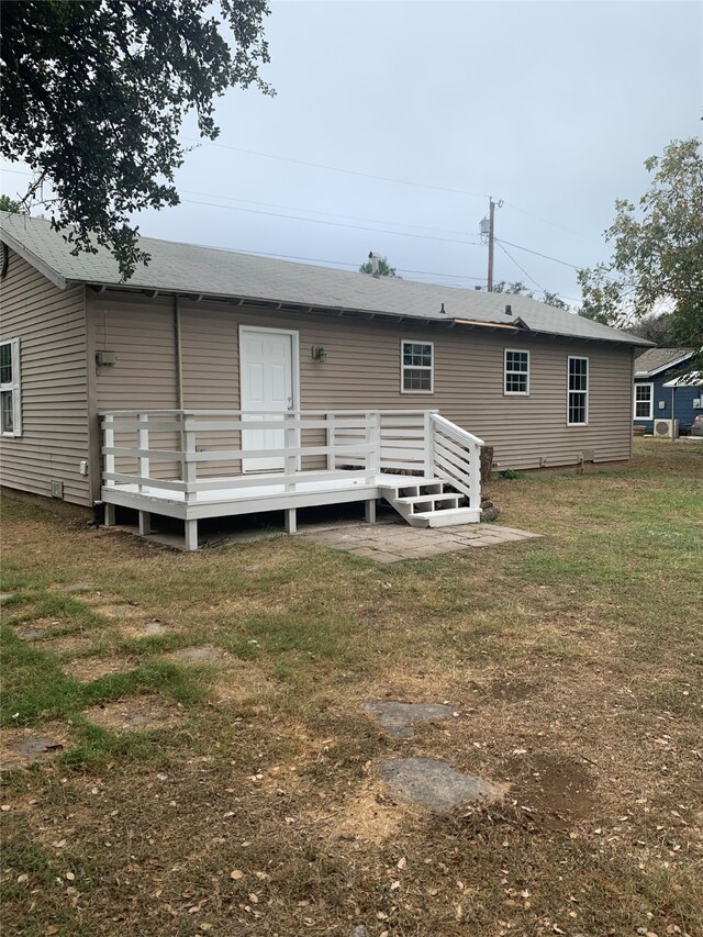 rear view of property with a lawn and a deck