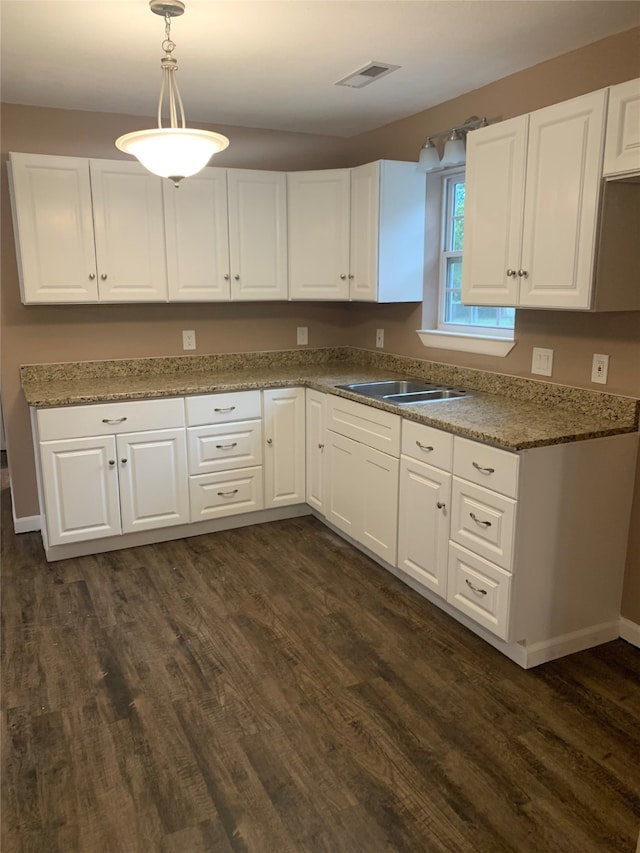 kitchen featuring white cabinetry, dark wood-type flooring, pendant lighting, and sink