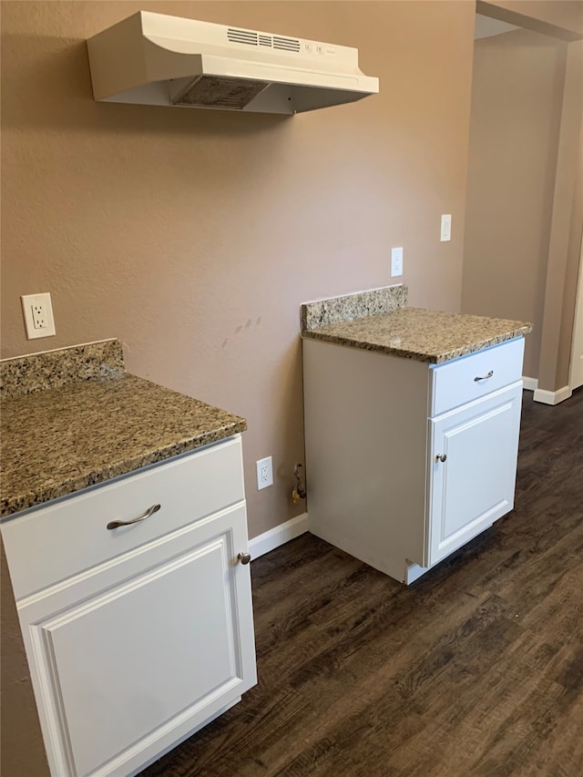 kitchen with white cabinets, stone countertops, dark hardwood / wood-style flooring, and range hood