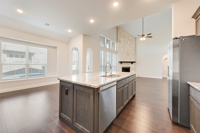 kitchen with sink, dark hardwood / wood-style flooring, light stone counters, and appliances with stainless steel finishes