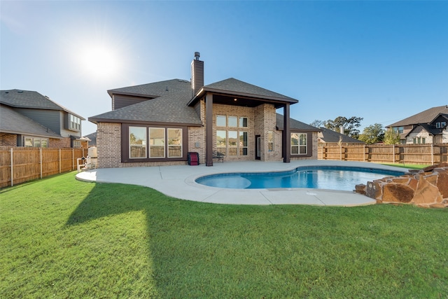 rear view of property with a patio area, a fenced in pool, and a yard