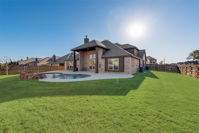 rear view of house with a yard, a fenced in pool, central AC unit, and a patio area