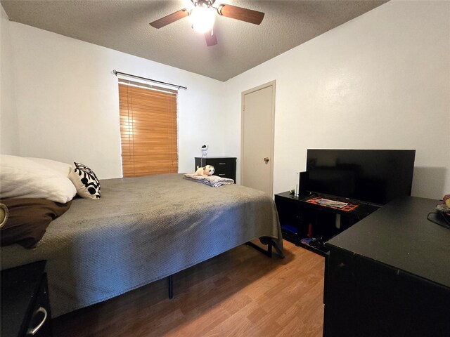 bedroom with ceiling fan, light hardwood / wood-style floors, and a textured ceiling