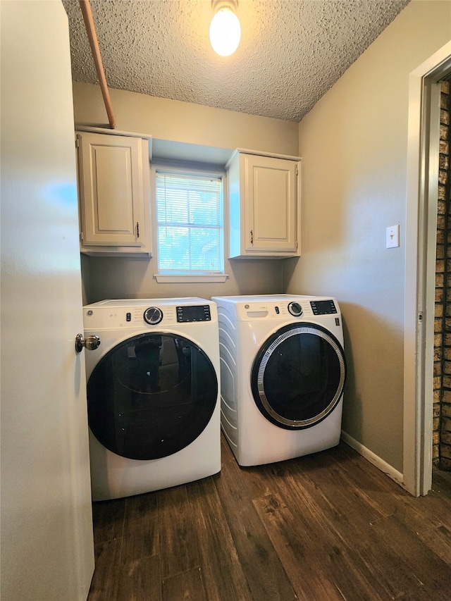 washroom featuring cabinets, a textured ceiling, dark hardwood / wood-style floors, and washer and dryer