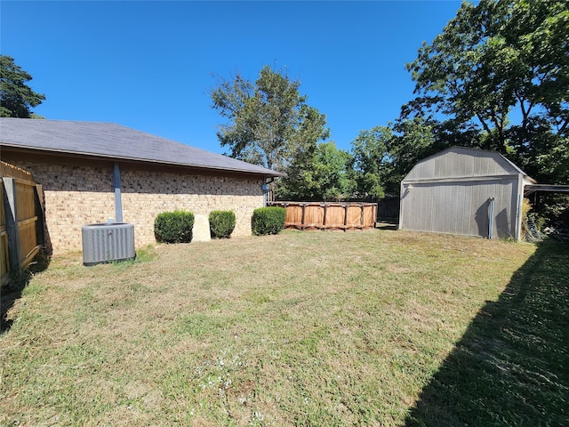 view of yard with central AC unit and a storage shed