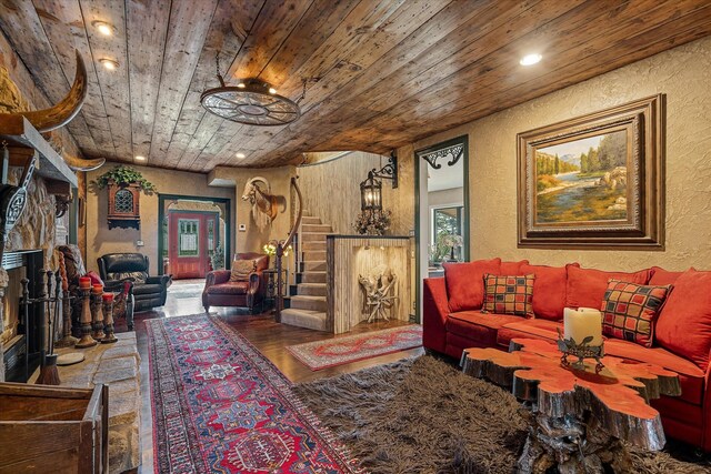 living room featuring hardwood / wood-style flooring, a stone fireplace, and wooden ceiling