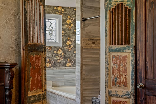 bathroom with a relaxing tiled tub