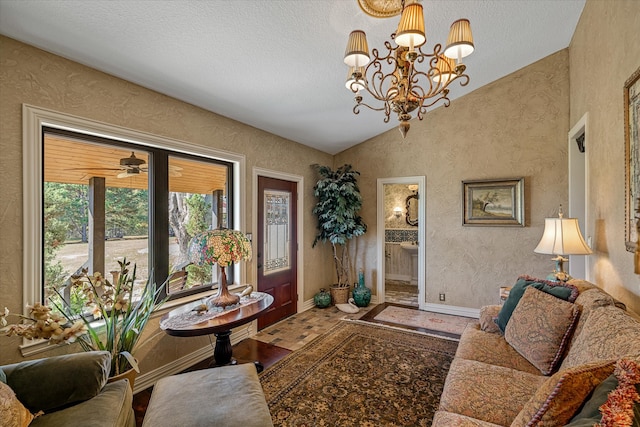 living room featuring ceiling fan with notable chandelier, a textured ceiling, and lofted ceiling