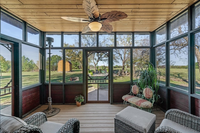 sunroom / solarium featuring a wealth of natural light, ceiling fan, and wood ceiling