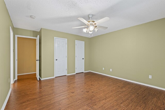 spare room featuring ceiling fan, wood finished floors, visible vents, and baseboards