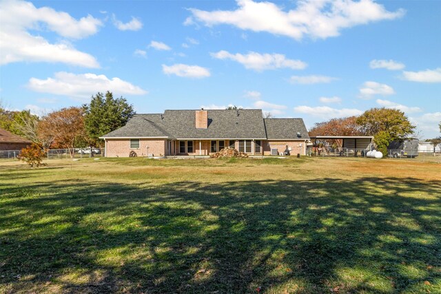 back of house featuring a yard, a chimney, and fence