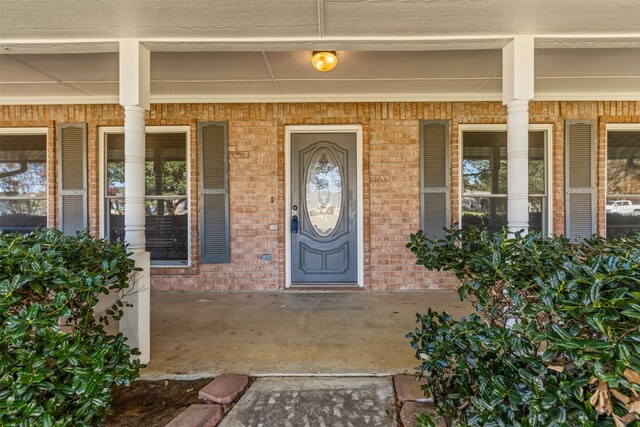 foyer entrance featuring ornamental molding, a textured wall, dark wood-type flooring, and baseboards