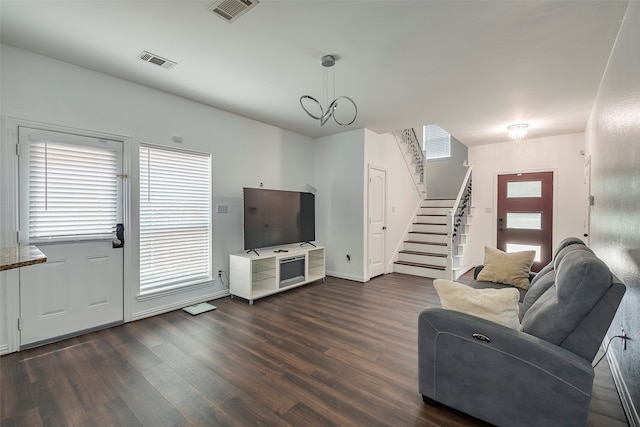 living room with dark hardwood / wood-style floors and an inviting chandelier