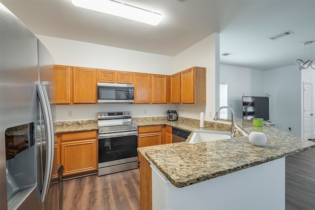 kitchen featuring dark wood-type flooring, sink, light stone counters, kitchen peninsula, and stainless steel appliances