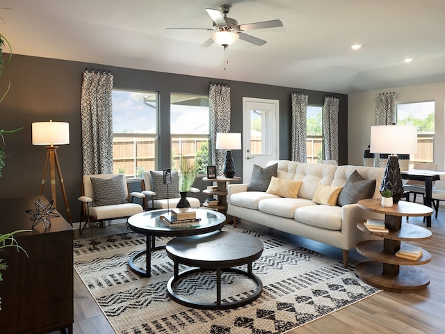 living room featuring plenty of natural light, ceiling fan, and wood-type flooring