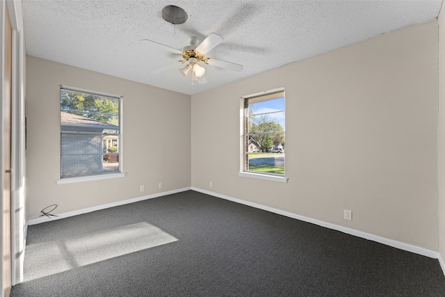 spare room with carpet, a textured ceiling, a wealth of natural light, and ceiling fan