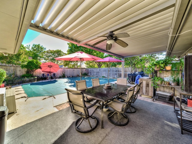 view of patio / terrace featuring ceiling fan and a covered pool