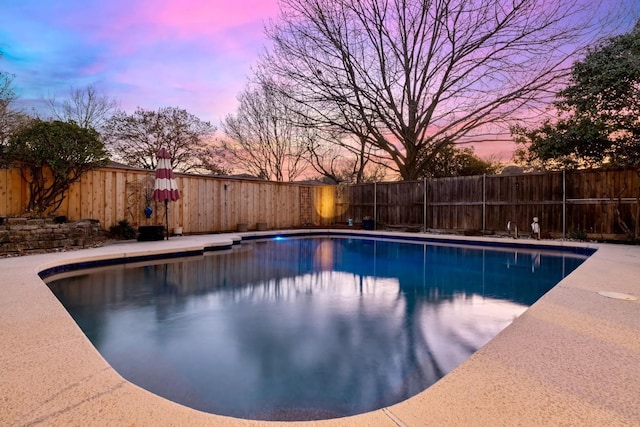 view of pool at dusk