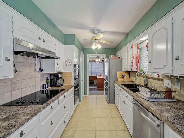 kitchen with white cabinets, light tile patterned flooring, backsplash, and appliances with stainless steel finishes