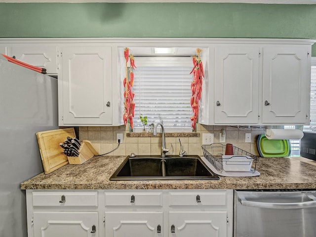 kitchen with stainless steel appliances, sink, white cabinets, and decorative backsplash