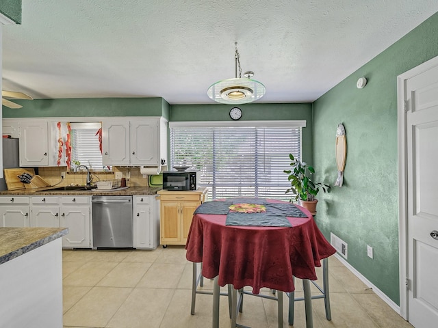 kitchen featuring white cabinets, a textured ceiling, stainless steel dishwasher, and ceiling fan