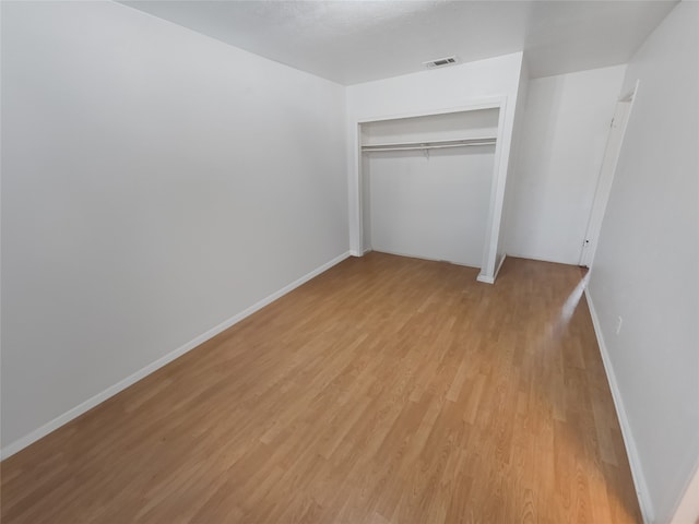 unfurnished bedroom featuring light wood-type flooring and a closet