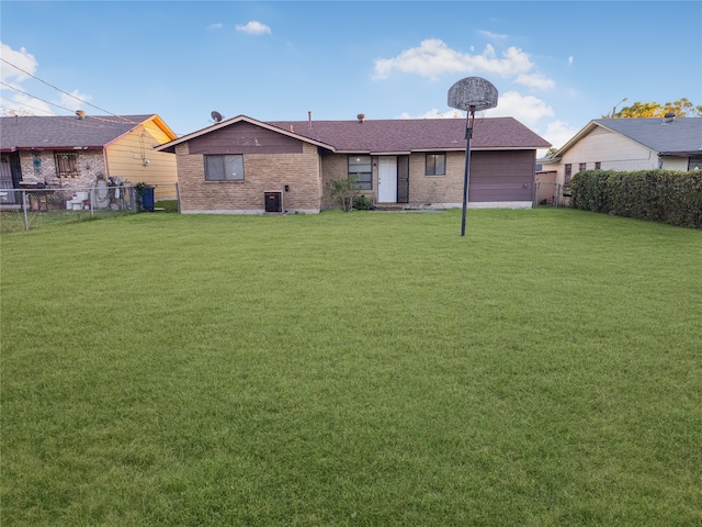 rear view of house featuring a lawn and central AC unit