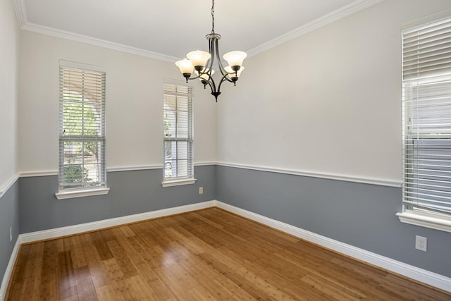 unfurnished room featuring a chandelier, hardwood / wood-style floors, and ornamental molding