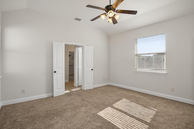 unfurnished bedroom featuring carpet, ceiling fan, and vaulted ceiling