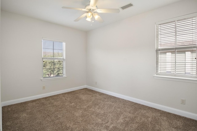 carpeted spare room featuring ceiling fan