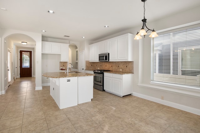 kitchen with white cabinetry, light stone counters, sink, and appliances with stainless steel finishes