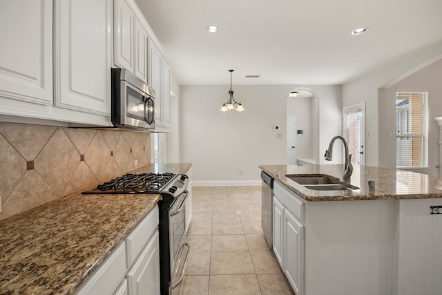 kitchen featuring a center island with sink, white cabinets, sink, and appliances with stainless steel finishes