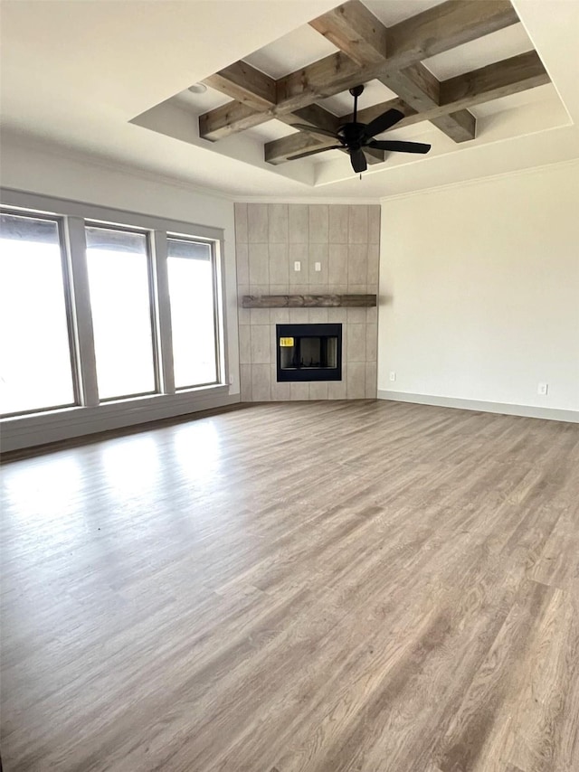 unfurnished living room with a fireplace, light hardwood / wood-style flooring, coffered ceiling, and beamed ceiling