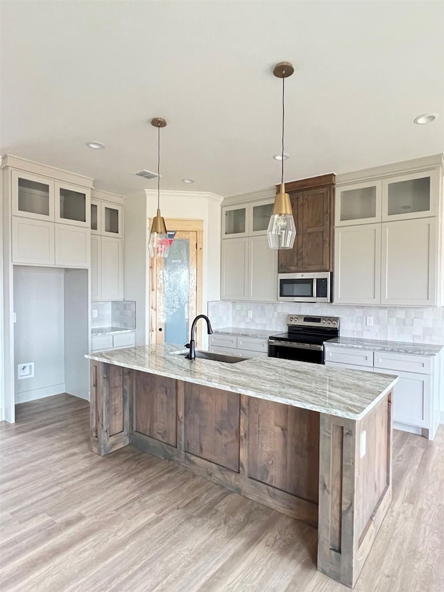 kitchen with decorative light fixtures, stainless steel appliances, and a large island