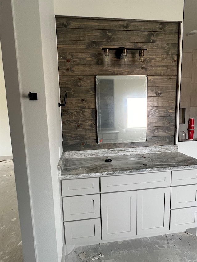 bathroom featuring vanity and wooden walls