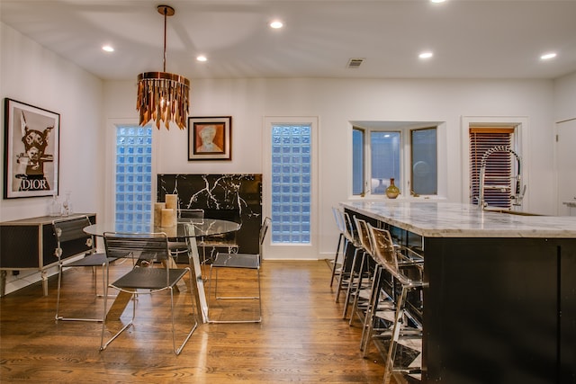 interior space with light stone countertops, pendant lighting, and dark hardwood / wood-style flooring