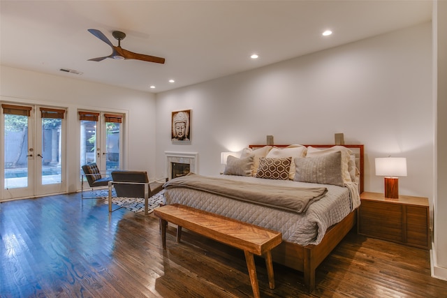 bedroom featuring french doors, dark hardwood / wood-style flooring, access to outside, ceiling fan, and a fireplace